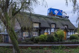Tesco home delivery van on the roof of a cottage